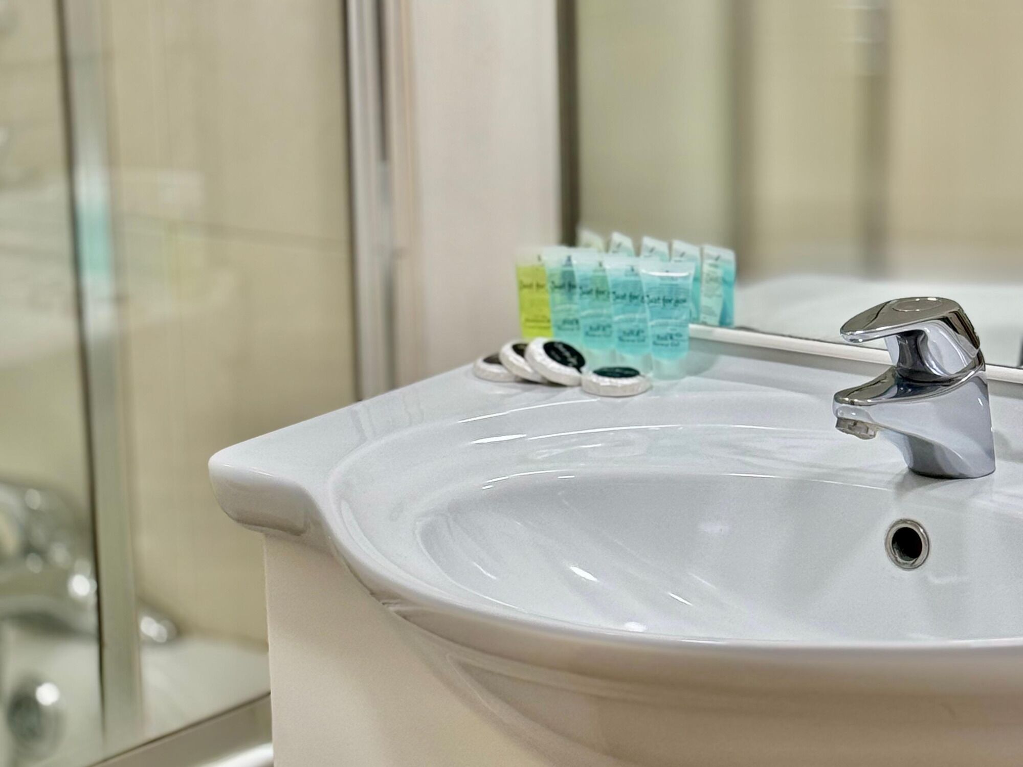 Un lavabo de salle de bain avec un robinet chromé et un porte-brosses à dents contenant des brosses à dents.
