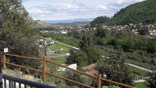 Un balcón con vistas a un pueblo y colinas.