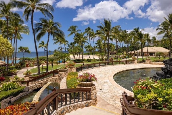 Un resort con piscina, palmeras y vista al océano.