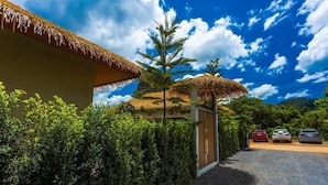A resort with a thatched-roof building, a gravel driveway, and parked cars. - Secret gem Villa Tropical design Private Pool Mountain View (Aonang)