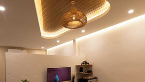 A modern living room with a flat-screen TV, a sofa, a coffee table, a small kitchen area, and a decorative ceiling light. - Secret gem Villa Tropical design Private Pool Mountain View (Aonang)