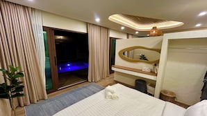 A hotel room with a bed, a bathroom with a mirror, a small plant, and a view of a pool area. - Secret gem Villa Tropical design Private Pool Mountain View (Aonang)