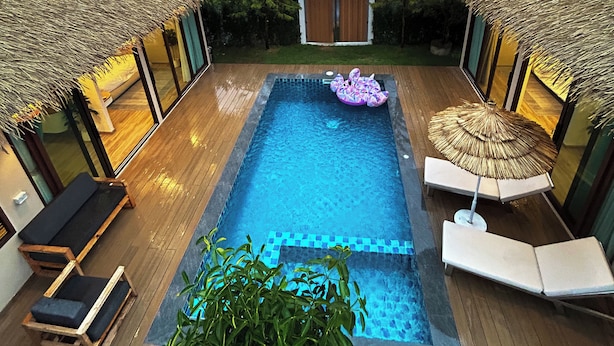 A pool area with wooden deck, lounge chairs, and a thatched-roof structure. - Secret gem Villa Tropical design Private Pool Mountain View (Aonang)