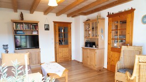 A cozy room with wooden furniture, a dining table, and a television.