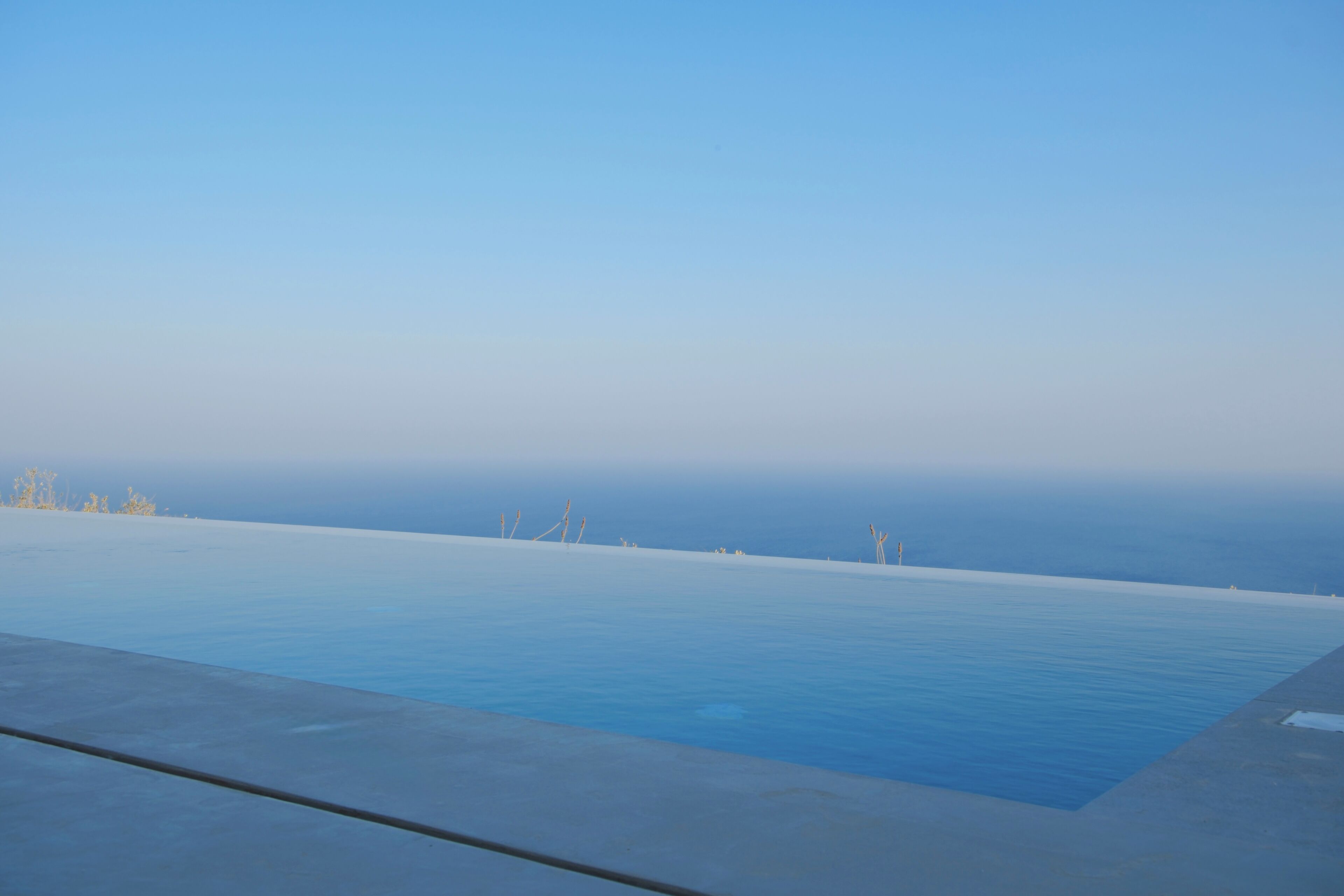Cielo azul despejado sobre una piscina con vista al horizonte.