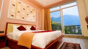 A bedroom with a large bed, a view of mountains, and a window with curtains. - MVT Resort & Restaurant (Rishikesh)