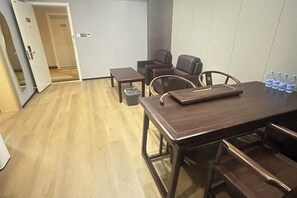A conference room with a wooden table, chairs, a trash bin, and water bottles. - Super 8 Hotel (Zhenhua Shopping Center, Liaocheng Development Zone) (Liaocheng)