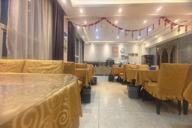 Un restaurante con cabinas, mesas, una barra y suelo de baldosas.