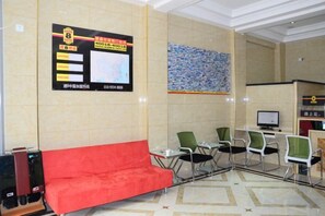 A hotel lobby with a reception desk, a red sofa, and a bulletin board with information. - Super 8 Hotel (Zhenhua Shopping Center, Liaocheng Development Zone) (Liaocheng)