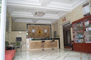 A hotel reception area with a marble floor, a reception desk, a waiting area with chairs, and a display cabinet. - Super 8 Hotel (Zhenhua Shopping Center, Liaocheng Development Zone) (Liaocheng)