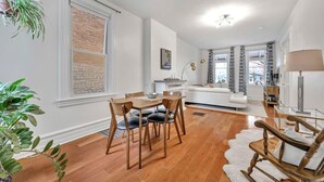 A modern living room with a dining area, a sofa, and a fireplace. - Downtown Lancaster Luxury 4BR - Garage & Parking (Lancaster)