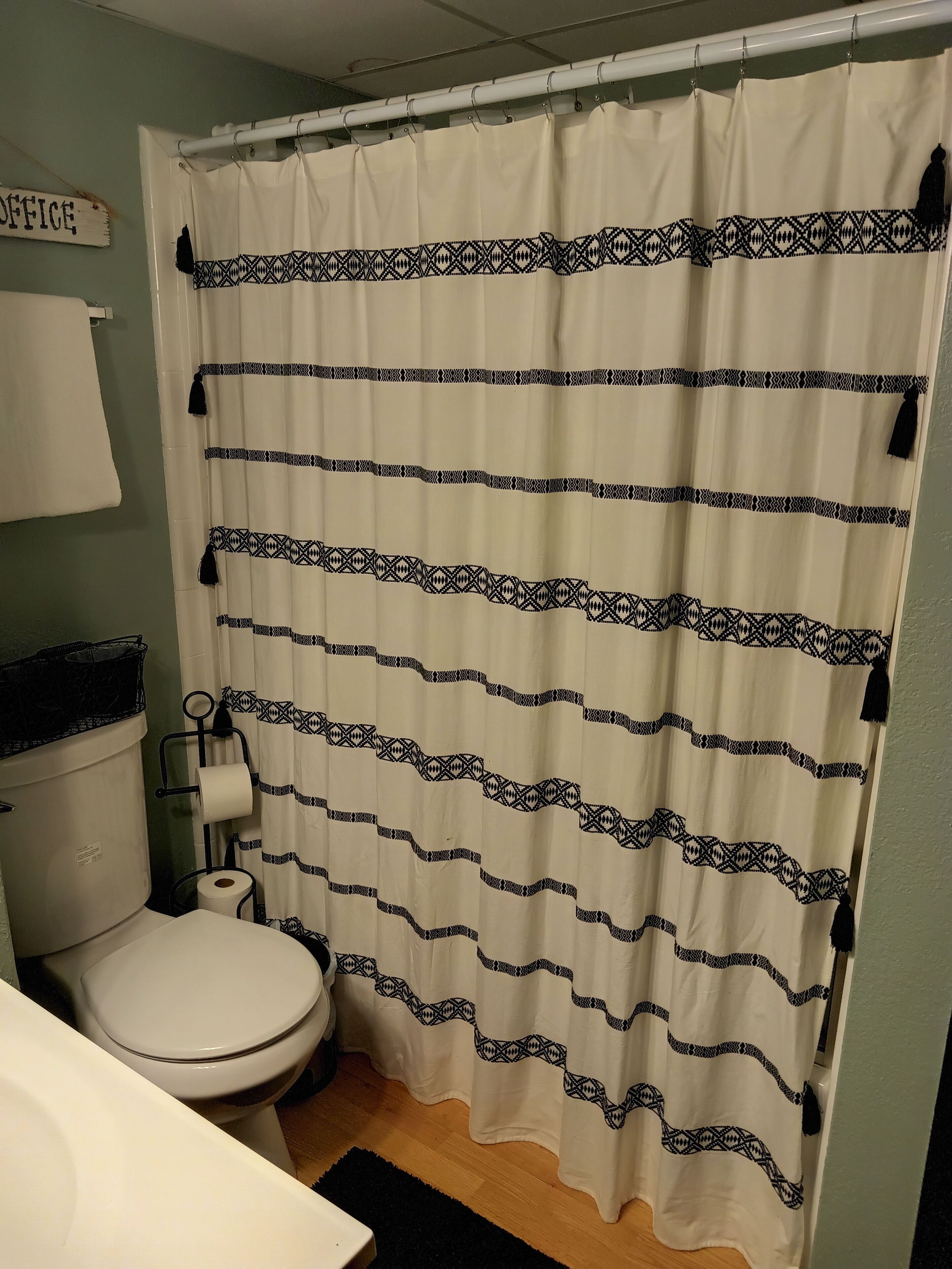 Un baño con inodoro, lavabo y cortina de ducha.