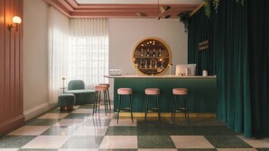 Un espace bar avec un sol à carreaux, des tabourets de bar, un comptoir de bar rond et un ventilateur de plafond.