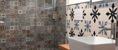 Une salle de bain avec douche, toilettes et lavabo.