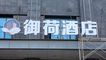 A hotel sign with Chinese characters and a logo.