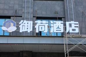 A hotel sign with Chinese characters and a logo. - City Convenience Hotel (Yingcheng Railway Station Shanghe Square) (Yingcheng)