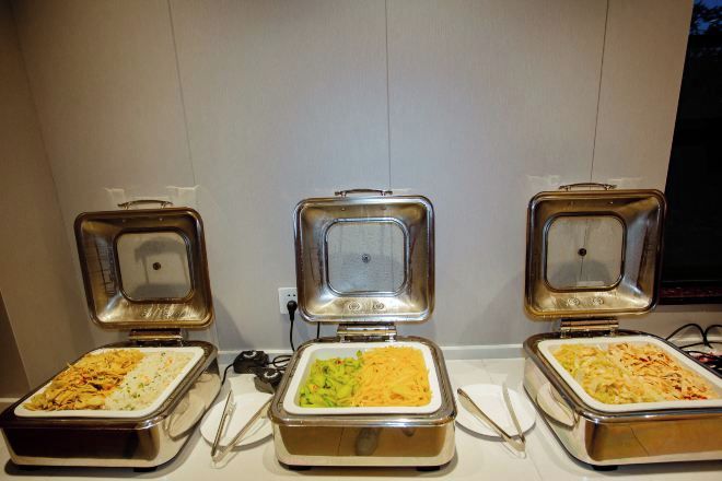 Three buffet-style food dispensers with different dishes.