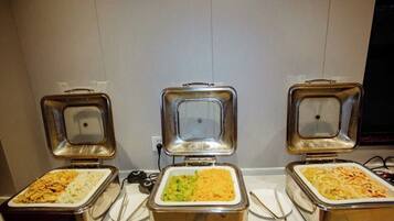 Three buffet-style food dispensers with different dishes.