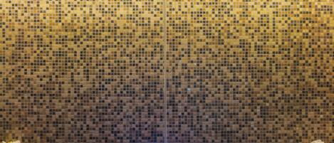 Un jacuzzi con pared de mosaicos y techo de madera.