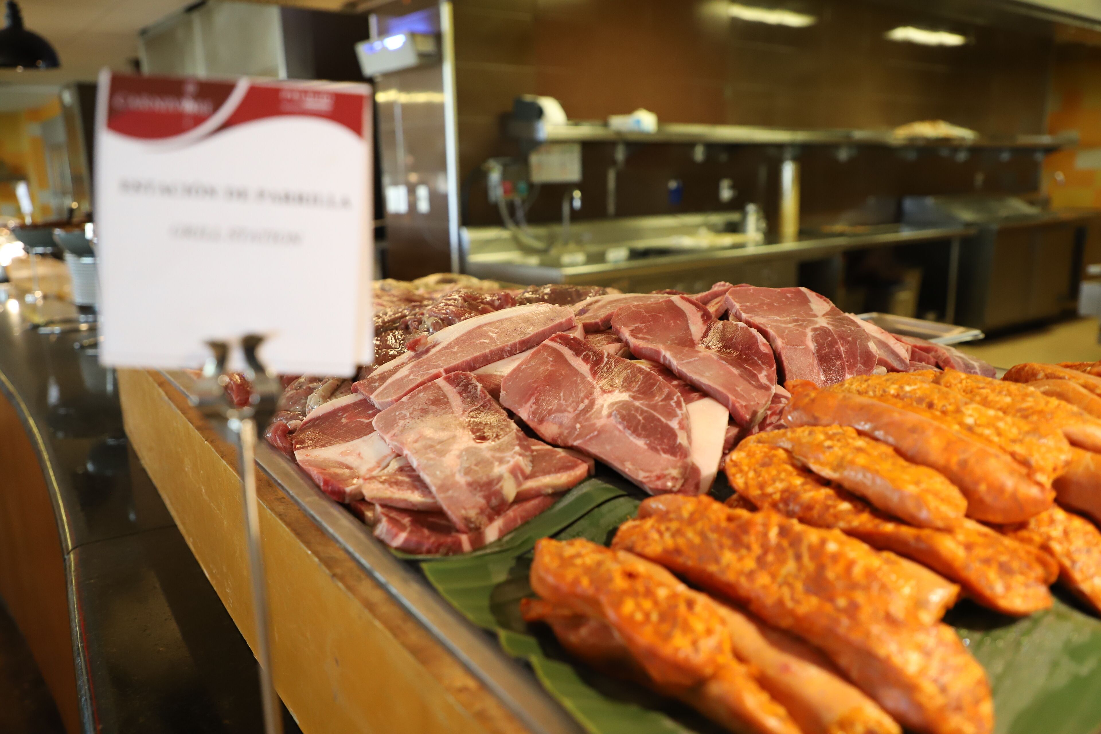 Un présentoir de viandes avec différentes coupes de viande et des saucisses.