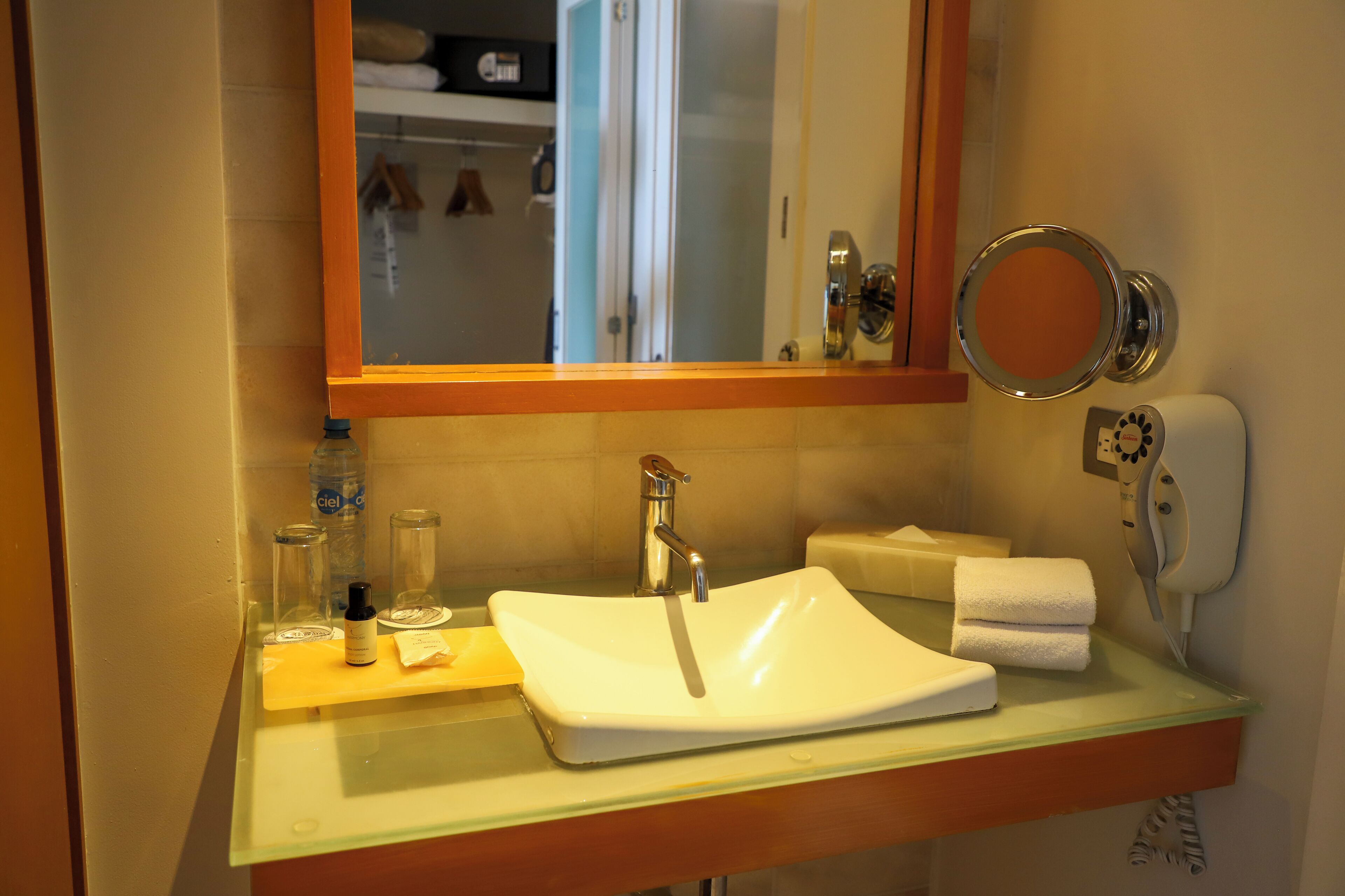 A bathroom with a white sink, a mirror, and a towel rack.