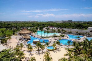 A resort with multiple swimming pools, palm trees, and a beach area. - Palacio Mundo Imperial All Inclusive Resort (Acapulco)