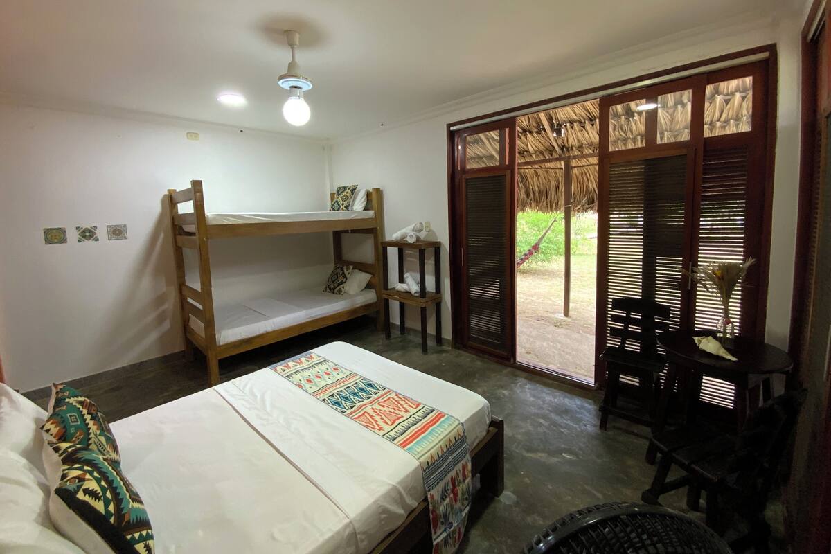 Una habitación con literas, un escritorio, una silla y vistas al exterior.