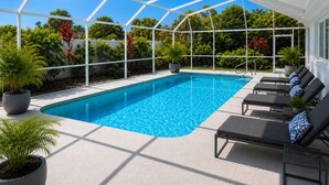 A swimming pool with lounge chairs and potted plants, surrounded by a white fence and greenery. - Walk to siesta key (Siesta Key)