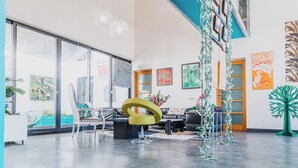 A spacious room with large windows, a modern chair, and artwork on the walls. - STAY AT THE ZEN LOFT (Bordeaux)