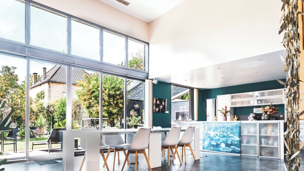 A modern interior with large windows, a bar area, and a seating arrangement. - STAY AT THE ZEN LOFT (Bordeaux)