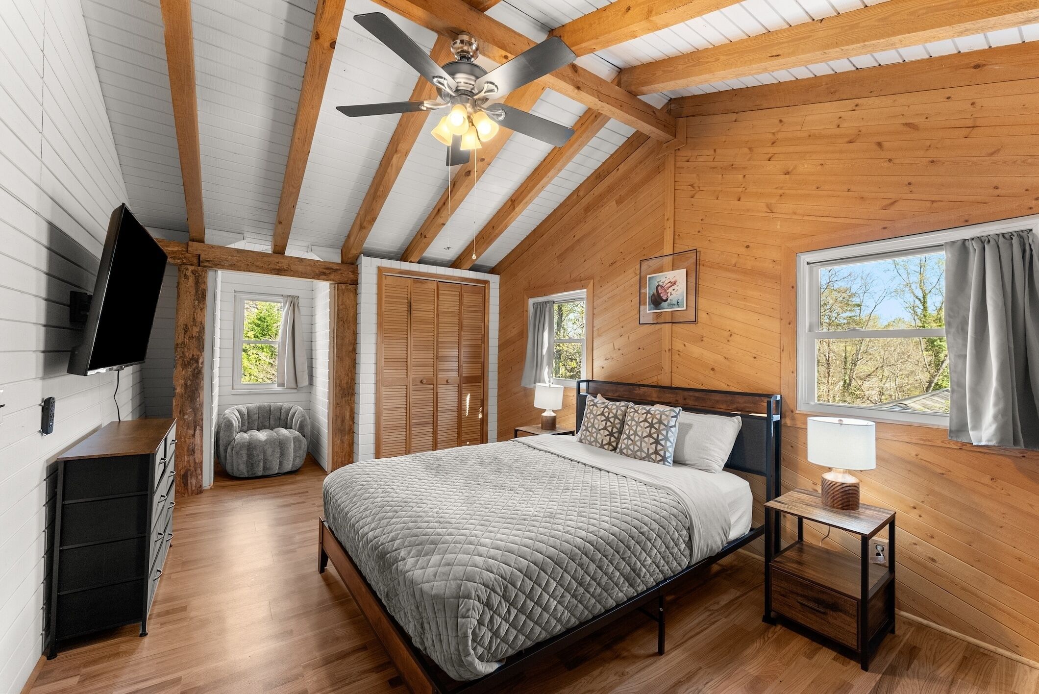 Un dormitorio con cama, mesita de noche, lámpara y ventilador de techo.
