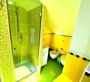 Een badkamer met douche, toilet en bidet.