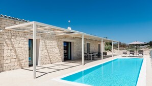 A stone building with a swimming pool, outdoor seating, and a pergola. - Villa La Siesta - Ragusa (Ragusa)