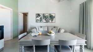 A modern kitchen with a central island, two pendant lights, and a dining area with a grey table and chairs. - Villa La Siesta - Ragusa (Ragusa)