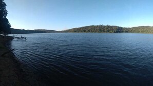 A calm lake with a forested hill in the background. - Holiday home for nature lovers (Baixa Verde)