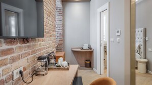 Eine moderne Küche mit Backsteinwand, Holz Arbeitsplatte und integriertem Fernseher.