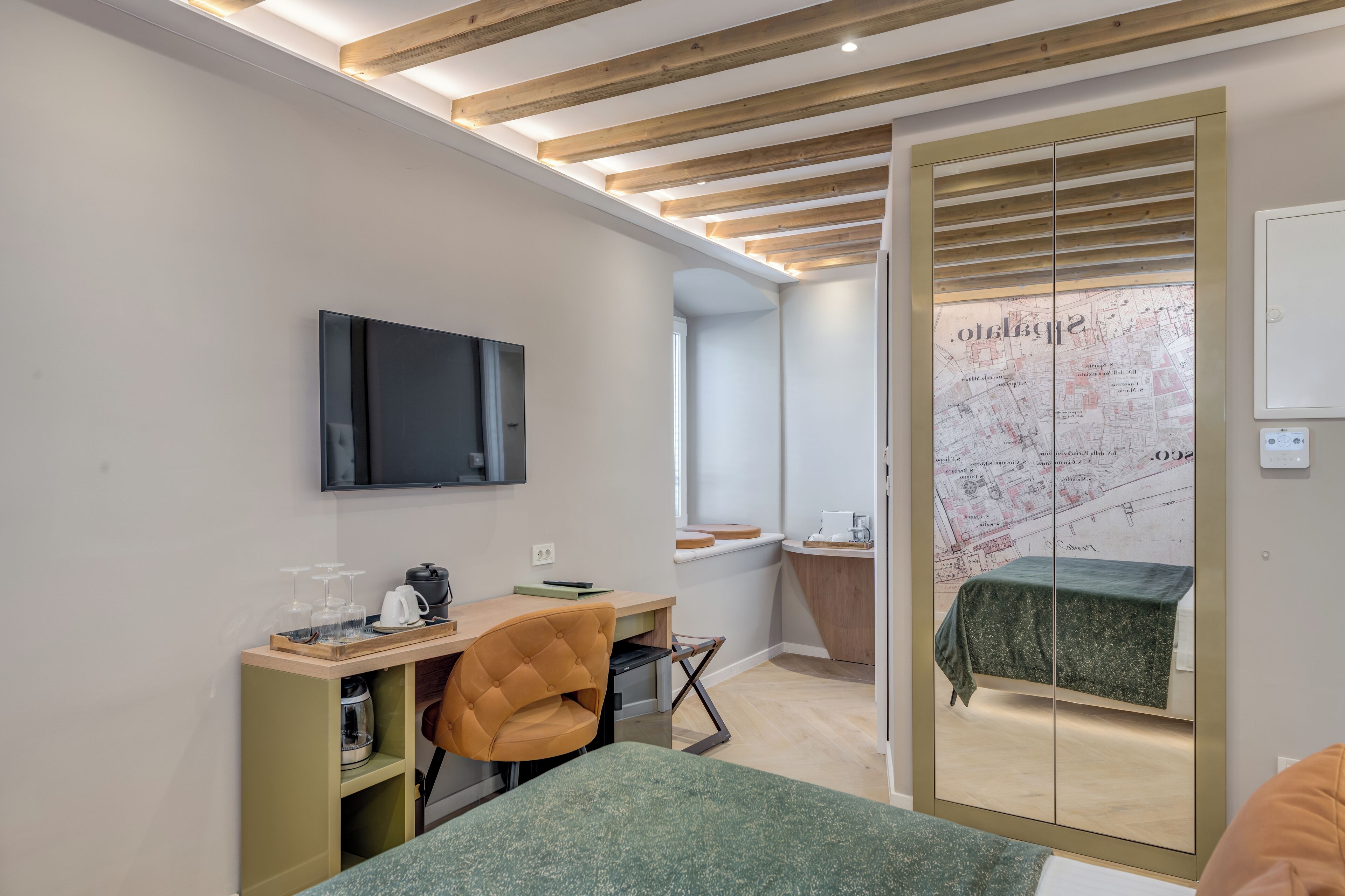 Una habitación moderna con una cama, un escritorio, una silla, un televisor y un mapa en la pared.