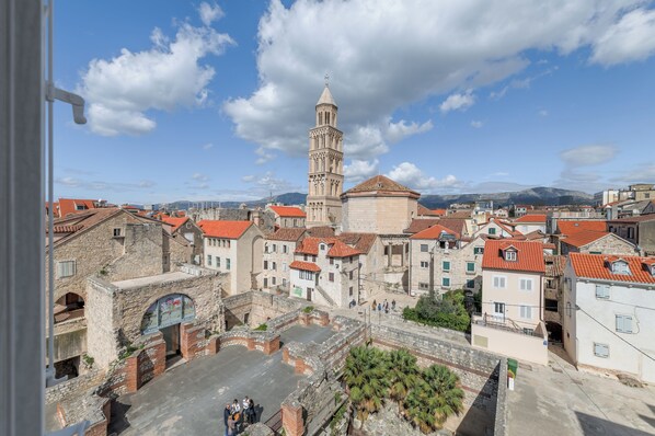 Un pueblo histórico con edificios de piedra, una torre destacada y una plaza empedrada.