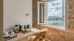 Eine Küche mit Meerblick, ein Fenster zum Schiff und eine Backsteinwand.