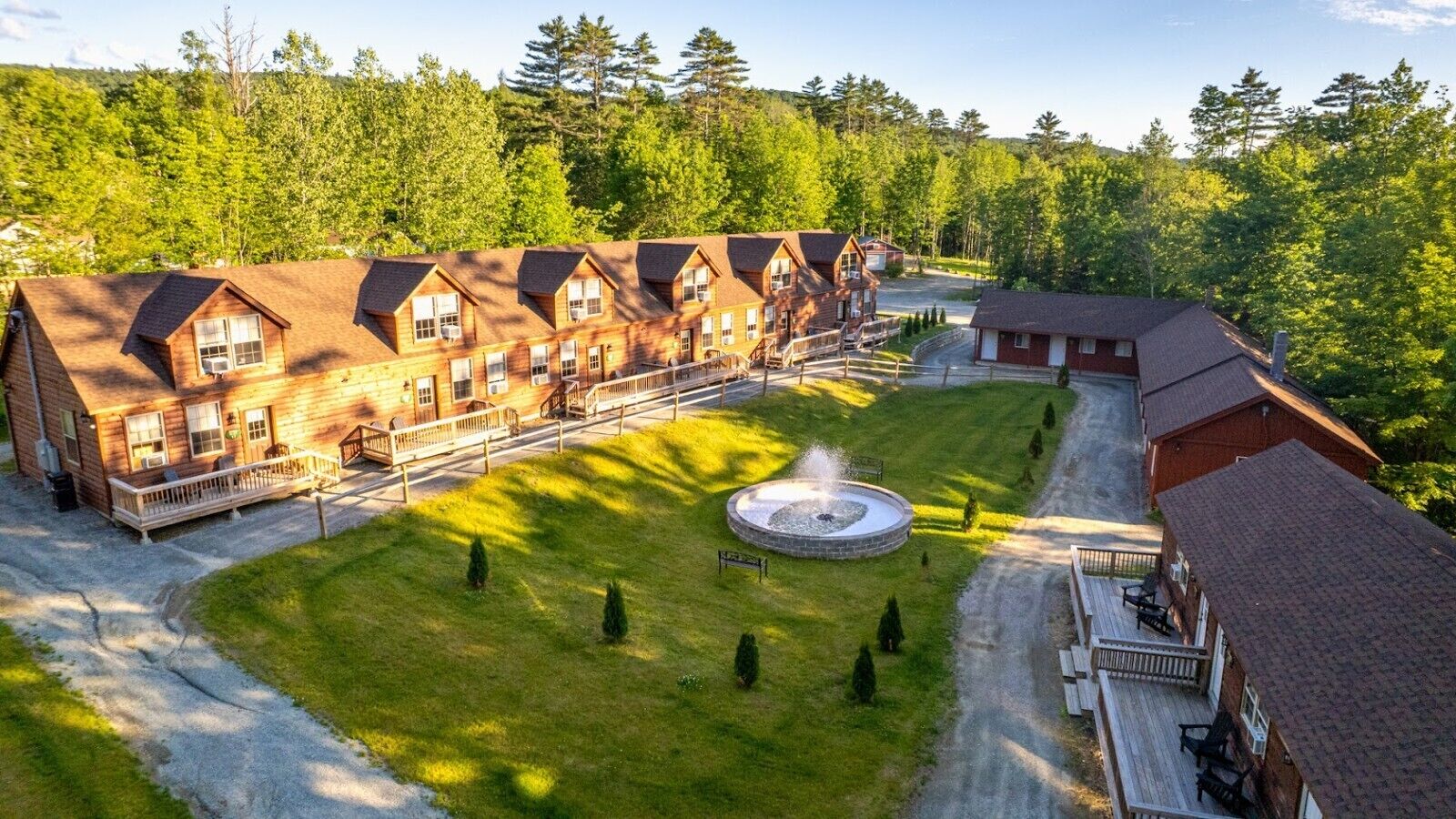 A lodge with multiple cabins, a central courtyard, and a fountain.