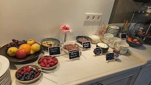 Un bufé con diversas opciones de comida y etiquetas en un entorno hotelero.