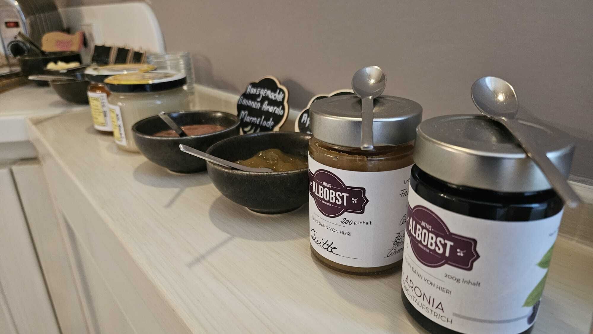 Una encimera de cocina con tarros de miel AlboBST y un bol de miel.