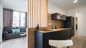 A modern kitchen with a wooden island, black cabinets, and a built-in microwave. - Apartment in Gran Canaria Near Maspalomas Dunes (San Bartolomé de Tirajana)