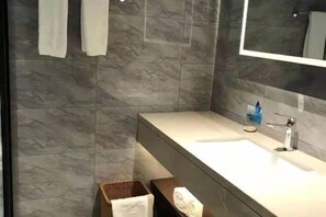 A modern bathroom with a marble backsplash, a large mirror, and a white sink. - Qifan Hotel (Kunming Railway Station Huannan South Road Metro Station Branch) (Kunming)