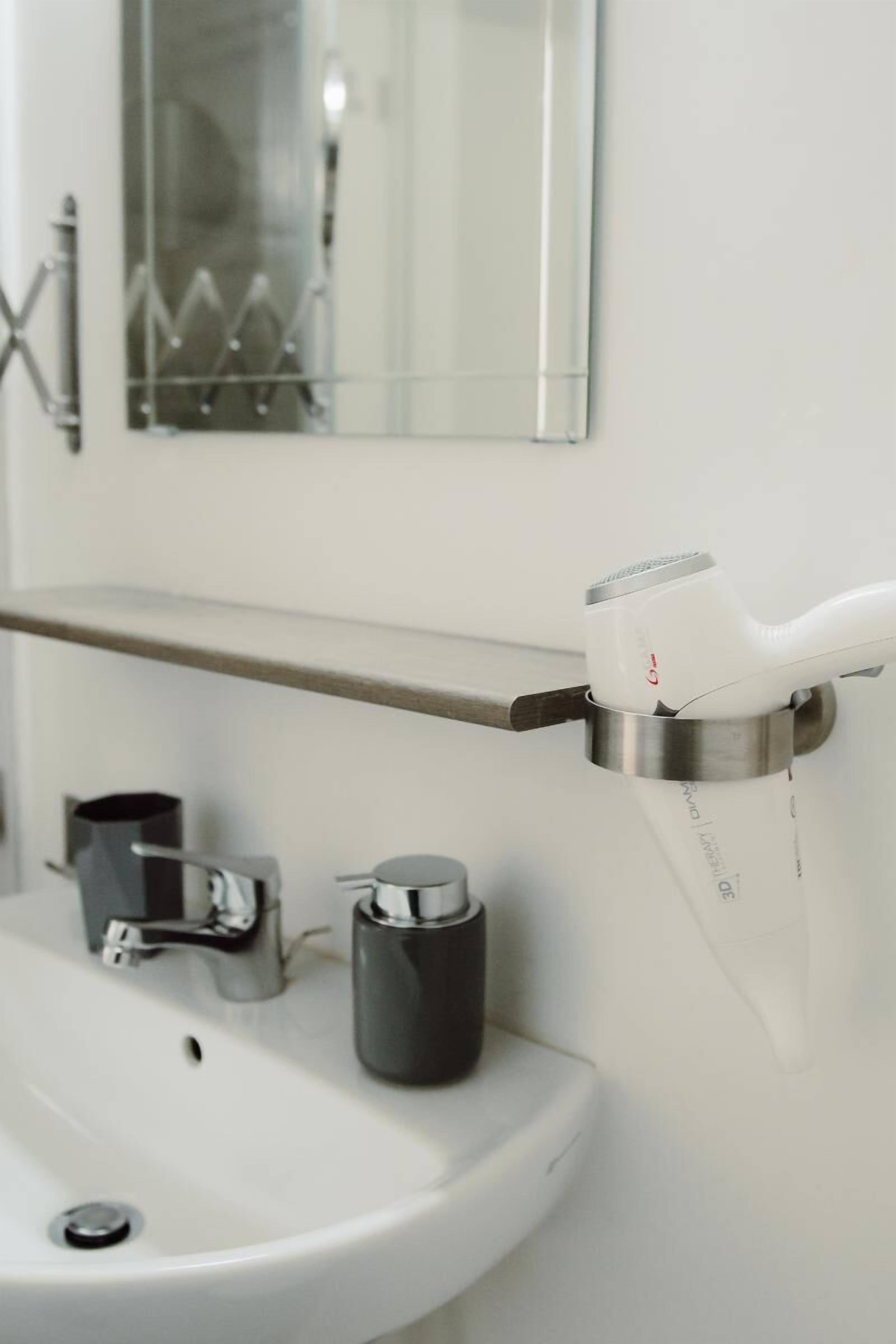 Ein Badezimmer mit Waschbecken, Spiegel und Handtuchhalter.