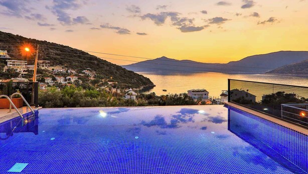 Μια πι σίνα με θέα σε μια παραθαλάσσια πόλη κατά τη διάρκεια του ηλιοβασιλέματος.