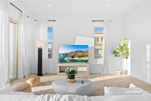 Relax in this stylish living room with a large flat-screen TV, comfortable seating, and a beautiful view.