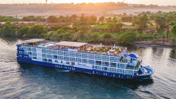 A large river cruise ship with multiple decks, including a swimming pool area on the upper deck.