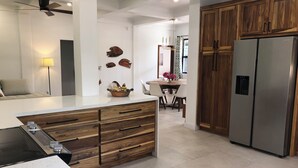 Eine moderne Küche mit Holzschnitzereien, einem Edelstahlkühlschrank und einem Essbereich mit Tisch und Stühlen.