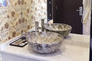 A bathroom with two large, decorative bowls as sinks, a mirror, and a tiled wall with floral patterns. - Ziwei Shishang Hotel (Shanghai)